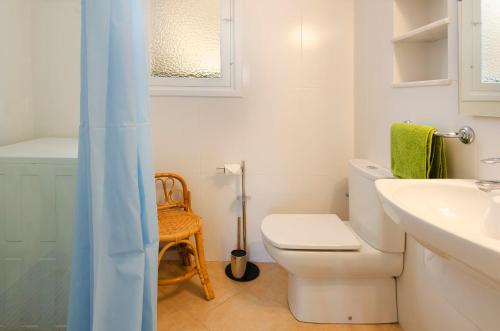 ein weißes Bad mit einem WC und einem Waschbecken in der Unterkunft Hostal Los Pinos in Cala de Sant Vicent