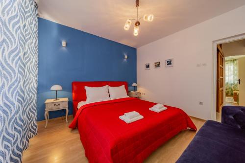 1 dormitorio con cama roja y pared azul en Villa Croatia Trogir, Center, 4 rooms, parking, jacuzzi, free beach and pool 15 min en Trogir