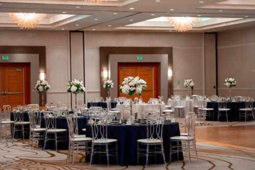 a ballroom with tables and chairs in a room with chandeliers at San Jose Marriott in San Jose