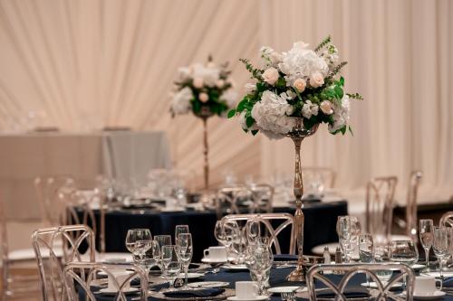 a room with tables with chairs and vases with flowers at San Jose Marriott in San Jose