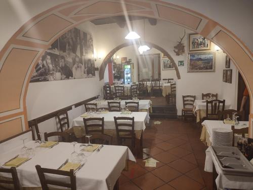 ein Restaurant mit weißen Tischen und Stühlen in einem Zimmer in der Unterkunft Ospitalità Baffone casa vacanze in Mercato