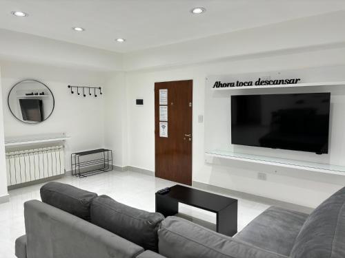 a living room with a couch and a flat screen tv at Urbano Esquel in Esquel