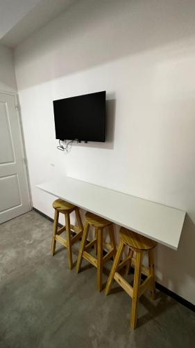a white table with chairs and a tv on a wall at DOCTA RESIDENCIA in Cordoba