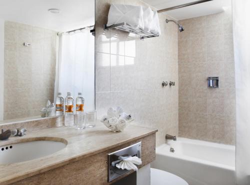 a bathroom with a sink and a tub and a toilet at Hotel Francia Aguascalientes in Aguascalientes