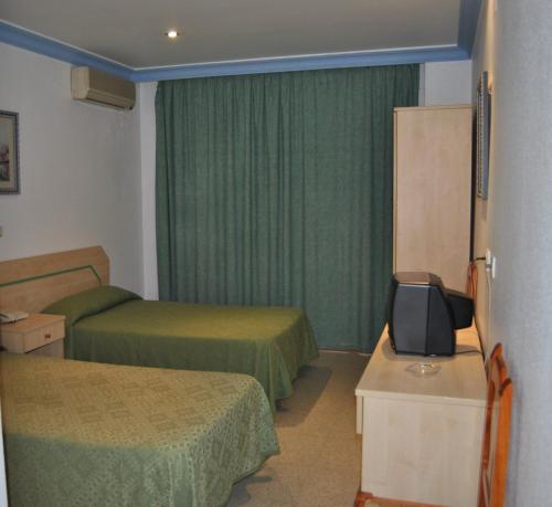 ein Hotelzimmer mit 2 Betten und einem TV in der Unterkunft Hostal Blumen in Algeciras