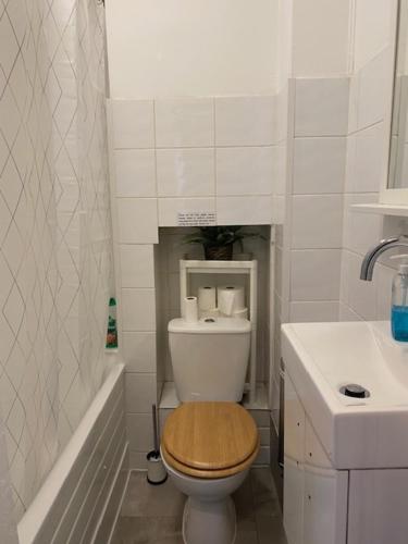 a bathroom with a toilet and a sink and a tub at Lord Merit Guest Rooms in King's Cross St Pancras in London