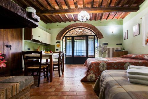 a bedroom with two beds and a table and a kitchen at Casa del Lecceto in Campiglia Marittima
