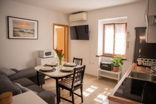 een keuken en een woonkamer met een tafel en stoelen bij Apartment Uno in Koper
