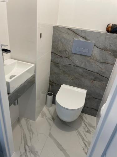 uma casa de banho com um WC branco e um lavatório. em Apartament Czeladź 60m2 Centrum Katowic 10km em Czeladź