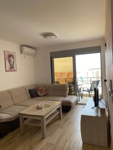 a living room with a couch and a table at Sunrise apartmani in Bar