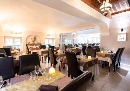 un restaurant avec des tables et des chaises en bois et un chercheur de table dans l'établissement Moulin de la Sambuc, à Saint-Zacharie