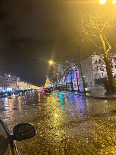 een natte straat 's nachts met lichten bij Gavril in Cergy