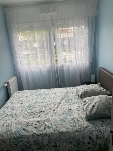 een bed in een slaapkamer met een raam bij Gavril in Cergy