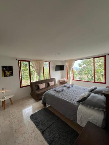 1 dormitorio con 1 cama grande y 1 sofá en Villa Ocampo en Salento