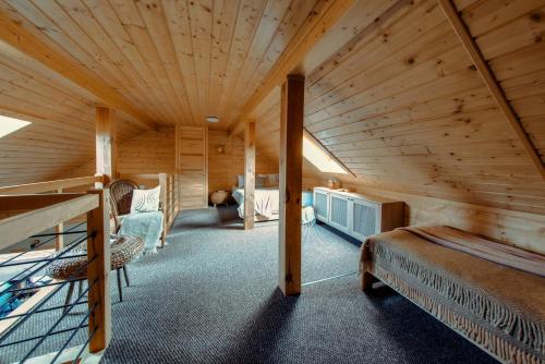 a log cabin bedroom with a bed and chairs at Dom Całoroczny Pola w Sierakowie in Sieraków