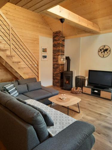 a living room with a couch and a fireplace at Dom Całoroczny Pola w Sierakowie in Sieraków