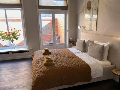 a bedroom with a bed with two towels on it at Hotel Stadsherberg Sneek in Sneek