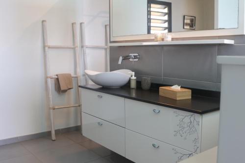 a bathroom with a sink and a mirror at Domaine entre ciel & mer Villa Dolce Vita in Deshaies