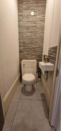 a small bathroom with a toilet and a sink at James House in Bescot