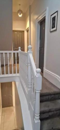 a white staircase with a white railing in a house at James House in Bescot