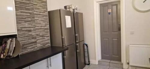 a kitchen with a stainless steel refrigerator in front of a door at James House in Bescot