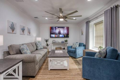 a living room with a couch and chairs and a ceiling fan at Your Seaside Sanctuary on Ocean Drive Awaits in Corpus Christi