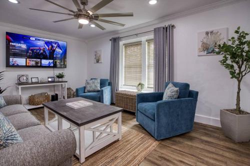 a living room with two blue chairs and a table at Your Seaside Sanctuary on Ocean Drive Awaits in Corpus Christi