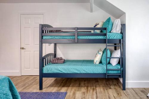 two bunk beds in a room with blue pillows at Your Seaside Sanctuary on Ocean Drive Awaits in Corpus Christi