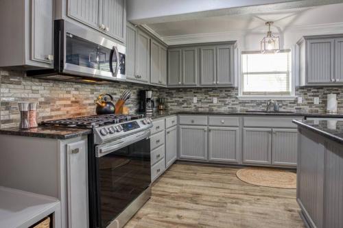 a kitchen with white cabinets and a stove top oven at Your Seaside Sanctuary on Ocean Drive Awaits in Corpus Christi