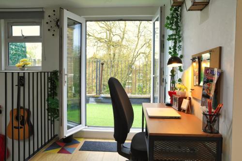 a home office with a desk and a sliding glass door at Top Floor Apartment in Islington in London