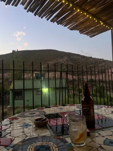a table with a bottle of wine and a view of a mountain at Sol de Alvear in General Alvear