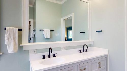 a bathroom with two sinks and a mirror at Sundancer in Southport