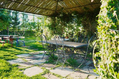 a picnic table and chairs under an umbrella at jnan Lemonie in Asilah
