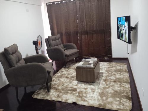- un salon avec des chaises, une table et un tapis dans l'établissement EDIFICIO PROGRESO, à Ciudad del Este