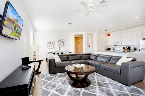 ein Wohnzimmer mit einem Sofa und einem Tisch in der Unterkunft 4BR Home - Private Pool and BBQ - Near Disney! in Davenport