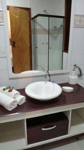 a bathroom counter with a sink and a mirror at Pousada Jupter in Teresópolis