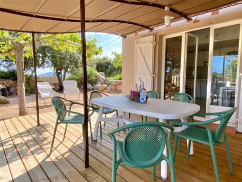 une table et des chaises sous un parasol sur une terrasse dans l'établissement Domaine de la Punta, à Porto-Vecchio