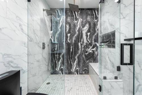 a shower with a glass door in a bathroom at Prime Location, Stylish Space: 3BR Home with BBQ in Los Angeles