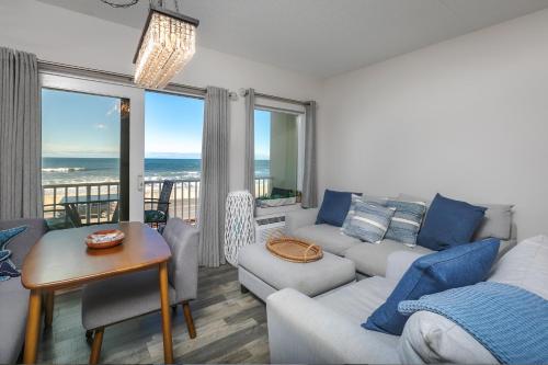 ein Wohnzimmer mit einem Sofa und einem Tisch in der Unterkunft Direct Oceanfront Studio Suite! in Hampton