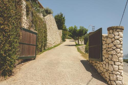 a road with a fence and a stone wall at Althea Studios Lefkada in Agios Nikitas