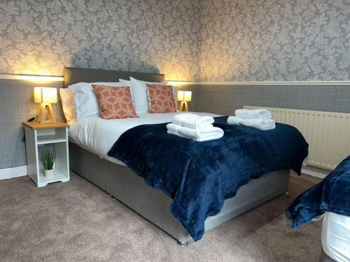1 dormitorio con 1 cama con toallas en Homely 3 Bed House Halifax, en Exley