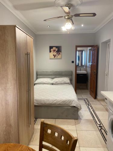 a bedroom with a bed and a ceiling fan at North London Studio Apartment in London