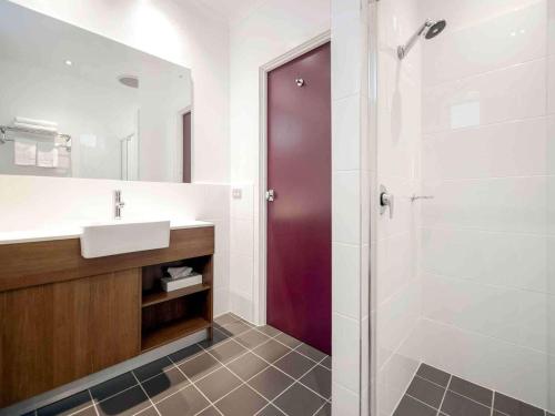 uma casa de banho com um lavatório e um chuveiro em Grosvenor Hotel Adelaide em Adelaide