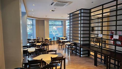 un restaurante con mesas, sillas y ventanas en Hotel Novi en Mar del Plata