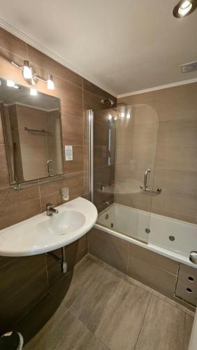馬德普拉塔的住宿－Hotel Novi，浴室配有水槽、淋浴和浴缸。