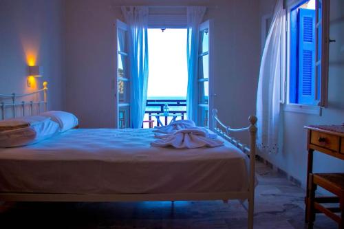 a bedroom with a bed and a window with a view at Thalassopoulia -Zephyrus Room in Ayía Kiriakí