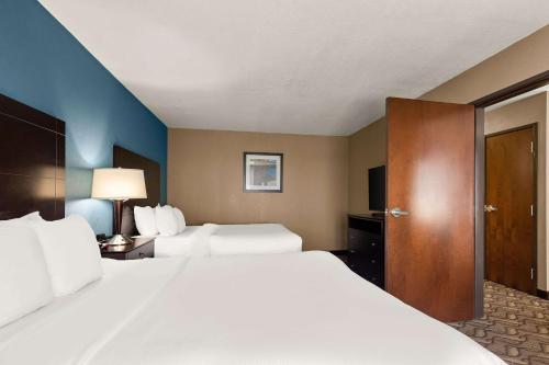 a hotel room with two beds and a door at Comfort Inn & Suites Springfield I-55 in Springfield