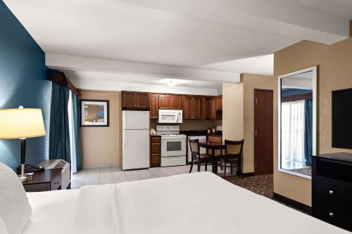 a hotel room with a bed and a kitchen at Comfort Inn & Suites Springfield I-55 in Springfield