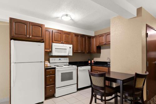 a kitchen with white appliances and a table with chairs at Comfort Inn & Suites Springfield I-55 in Springfield