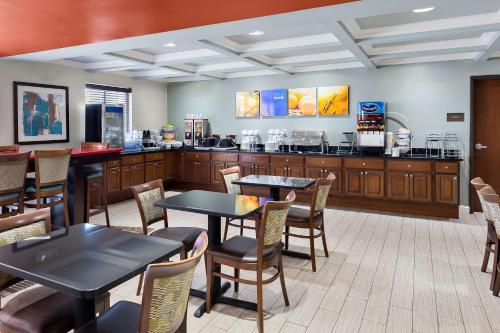 a restaurant with tables and chairs and a counter at Comfort Inn & Suites Springfield I-55 in Springfield